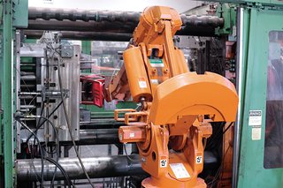 After the rPET mixture is heated and transformed via injection molding into a chair, a robotic arm removes it from the specially designed mold.