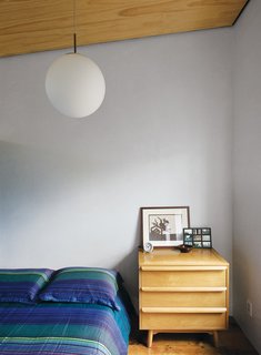 Family Home Renovation in Brooklyn - Photo 11 of 28 - Lange’s predilection for vintage design punctuates the space. The office level includes a cozy guest room with a mid-century Heywood Wakefield-esque dresser serving as a bedside table.