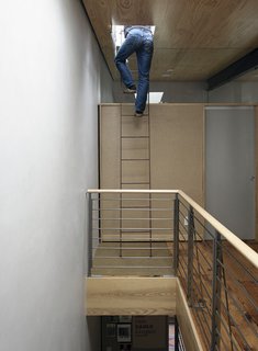 Family Home Renovation in Brooklyn - Photo 19 of 28 - On the top level of the brownstone, where the couple raised the ceiling to ten feet, architect Mark Dixon takes a ladder up to the roof.