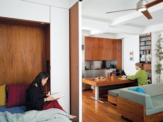 Screened by the sliding door, Rosa cozies up with a book in the bedroom, while across the apartment Robert uses the hydraulic kitchen table as a work desk. "We wanted to explore the power of custom design by creating integrated furniture to maximize both efficiency and aesthetics," says Rosa.