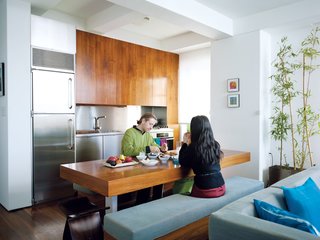 The walnut dining room table does quadruple duty as a work station and storage unit, and an eating and entertaining area.