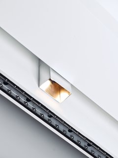 The couple really liked Prologue can lights by Kreon but couldn't afford them. So they bought aluminum sheets, sanded them, and folded them around standard track fixtures for a similar look. The total cost, including the transformer: about $40 per fixture.