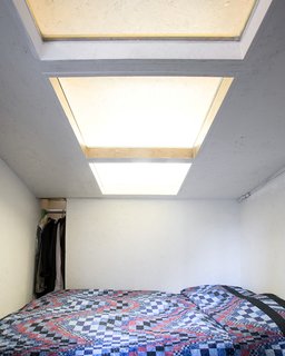 Communal Living on a Budget in Brooklyn - Photo 6 of 13 - A "Mohawk" skylight cuts across the ceiling of Dreitlein's room. The interior skylights bring in extra light and help the cell-like rooms feel more spacious.