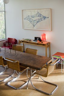 In the dining room, a painting by Victoria Haven hangs over a maple side table that Hale designed and built while in architecture school at the University of Washington. The dining table was a banquet table that Hale repurposed, and the Mies van der Rohe chairs were vintage store finds given to Hale and Edmonds as a housewarming gift.