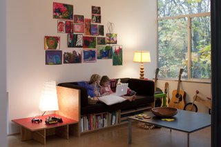 Back in the living room, the girls busy themselves with books. Hale designed and made the plywood couch with built-in book storage as well as the plywood-and-red-plastic-laminate side table. Hale's partner at Shed Architecture and Design, Thomas Schaer, created the Richlite-topped, steel-base coffee table.