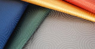 Kravet’s Sta-Kleen performance fabric is a throwback to the 1950s formaldehyde resin fabrics, with its faux leather feel, raised circular designs and availability in five bright hues.