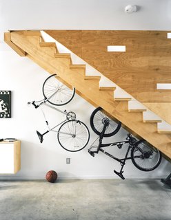 Green Urban Housing in Philadelphia - Photo 2 of 11 - More adult playthings, like this pair of bikes live under the stairs, whose cutouts break up the plane of plywood and double as peepholes for kids at play.