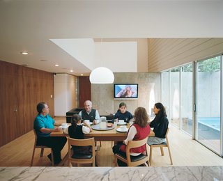 Marco Becerril, at the left end of the table, presides over his extended family in the double-height dining area.