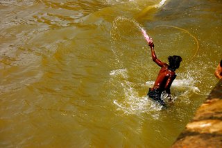 During the festival of Holi, Mumbai's inhabitants take to the streets and paint each other. This kid had enough and jumped in the harbor to wash himself clean.