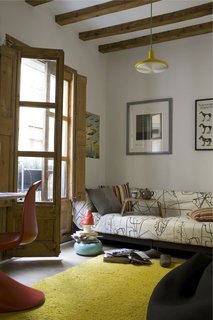 Green Living in Barcelona - Photo 2 of 14 - Wishing to avoid using harsh chemicals, the couple had the 18th-century beams and French doors in the living room and elsewhere sandblasted to rid them of woodlice. The rug, by Nani Marquina, is renewable and biodegradable as well as ethically produced.