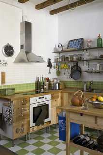 Green Living in Barcelona - Photo 6 of 14 - The kitchen cupboards were crafted from recycled wooden wine boxes, and the countertop is untreated wood certified by the Forest Stewardship Council (FSC) from Ikea. The green-and-white tiles are from a local company, TAU Cerámica.