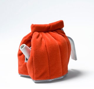 A bright orange tea cosy by Jongerius Lab.