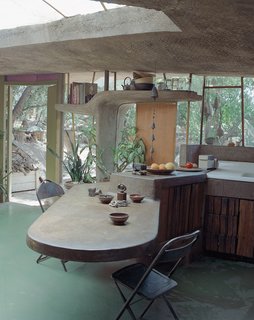 The Acrobatic Wonders of Concrete - Photo 9 of 10 - At a smaller scale than an entire building, a concrete cantilevered countertop and table extends both inside and outside at the Arizona home of Italian architect Paolo Soleri. A sculptural shelf frames the window and door beyond, with rounded edges for a softer, supple feel.