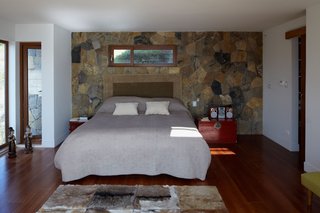 Tunquen Treasure - Photo 3 of 13 - From her bedroom on the lower level, Schneider can walk out onto her balcony and take in the spectacular views of the Pacific Ocean. The wall behind the bed is the thermal-mass wall that provides heat throughout the night.