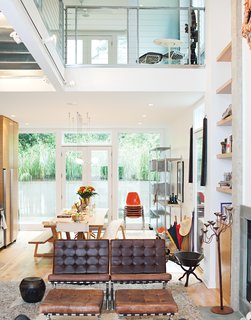 To create a sense of luxury on a budget, the architect ran a thin concrete border along either side of the fireplace flue and flanked it with floor-to-ceiling bookshelves. The second story has two lofts joined by a steel bridge.