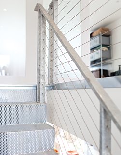 Nouvel Approach<br><br>When the Nouvel staircase proved too costly to copy, DeSalvo designed an affordable version. The treads are perforated bent steel plates that appear to float on a support tube, while the railings are made from tension cables and galvanized handrails and posts. It offers a similar level of architectural impact and sense of transparency at relatively low cost (both stairways, plus a matching catwalk, came in at $6,000).