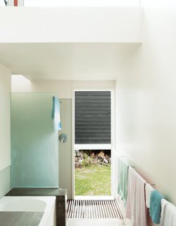 Bach to the Beach - Photo 10 of 30 - A bathroom with corrugated steel walls opens directly to the outdoors, making it easy to shower post-beach.