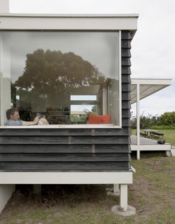 Bach to the Beach - Photo 16 of 30 - The glassy pavilion containing kitchen, dining, and living areas is elevated three feet off the ground on posts so it appears to hover among the dunes.