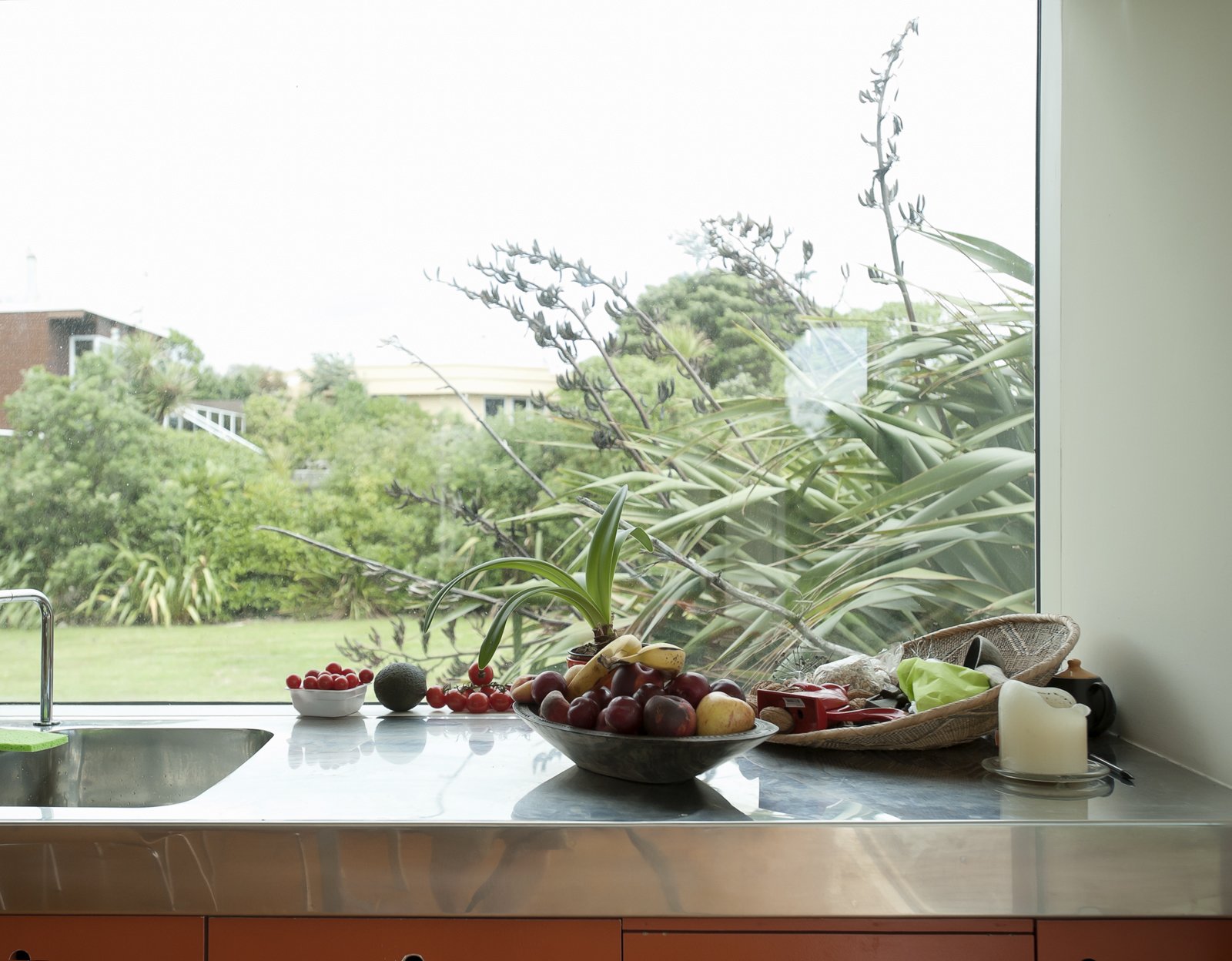 Stainless steel countertops are easy to clean and weightless-looking, helping bounce light around the kitchen.