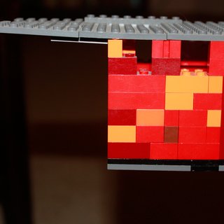 Building the Maxon House: Week 12 - Photo 3 of 11 - How do you represent oxidizing raw steel with Legos? A multicolored red, orange, and yellow mix helps represent the outer skin of our future home. The kids inspired me to create a rough model of our house based on our initial schematic plans. Here, a peek at the cantilevered portion of the house with the flat membrane roof.