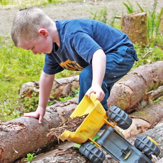 Building the Maxon House: Week 12 - Photo 8 of 11 - Charlie, our youngest sets up his own construction site on the property and transfers some wood chips with the help of his truck. He's practically grown up on the property and the transition to his future playground has been seamless.