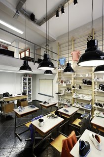 Desks line the center of the store and a shelf made from a climbing wall is in the background.