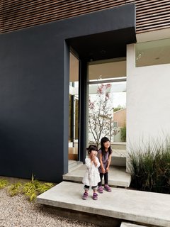 Yumi (left) and Maya (right) cheese around on the steps leading into the front door. Inside, there is ample space for removing and leaving one's shoes, another Japanese element.