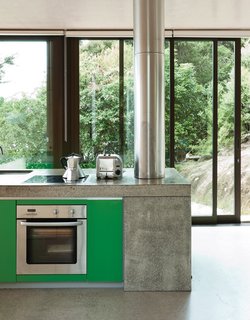 A pop of color in the kitchen cabinets refers to the native greenery outside.