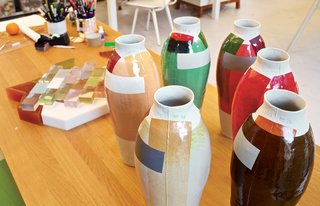 On a work table, a cluster of early color experiments foretells her 300 Unique Vases project.