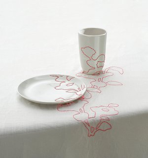 1999<br><br>Embroidered Tablecloth continues patterns derived from Ming vases across plates and cups.