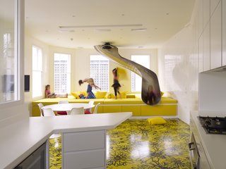 "The amount of work that was done to get things to look so naïve was phenomenal," Rogers says. "We are quite hedonistic in our play on space." This custom sofa offers a soft landing for the roundabout slide, which emerges from a trapdoor in the master bedroom above.