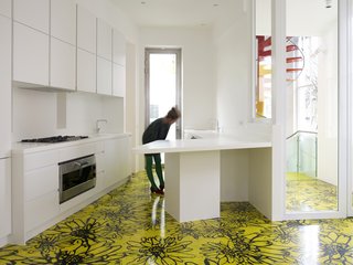 A view of the kitchen, with a glimpse of the spiral staircase in the background.