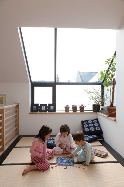 Mika, Kiku, and Kaz'ma play in the tatami room beneath the big skylight. The cushions on the floor were sent from Japan by the childrens's grandmother. The tatami mats were actually purchased in the UK from the Futon Company. Gaffney notes that they're not the proper dimensions of Japanese tatami mats, but they were much less expensive than importing the real thing.