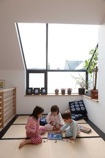Mika, Kiku, and Kaz'ma play in the tatami room beneath the big skylight. The cushions on the floor were sent from Japan by the childrens's grandmother. The tatami mats were actually purchased in the UK from the Futon Company. Gaffney notes that they're not the proper dimensions of Japanese tatami mats, but they were much less expensive than importing the real thing.