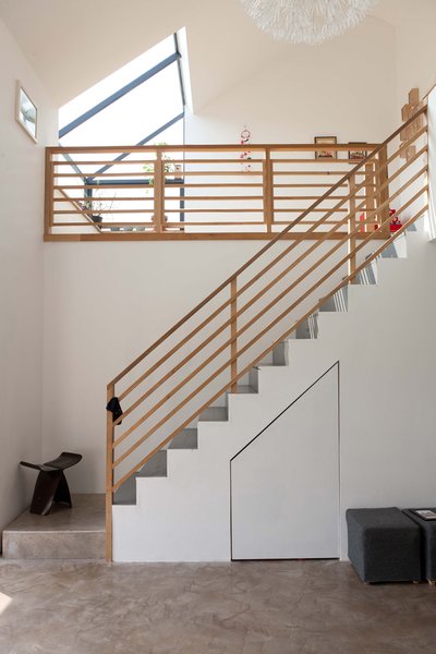 The spatial drama on the interior comes from the staircase and tatami room upstairs. The daffodil pendant overlooking it all is from Ikea. The butterfly stool is by Sori Yanagi and was a birthday present from Konishi to Gaffney.