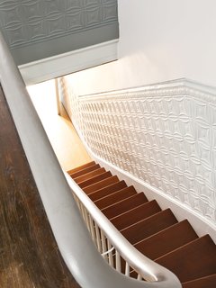 The tin panels lining the stairs are original to the house.