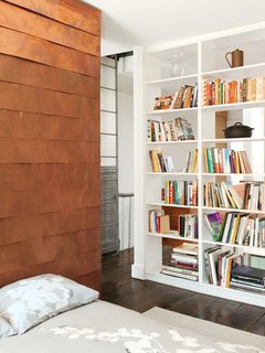 The copper-covered volume proceeds to the second floor, where it forms a storage wall in Sherman’s home office