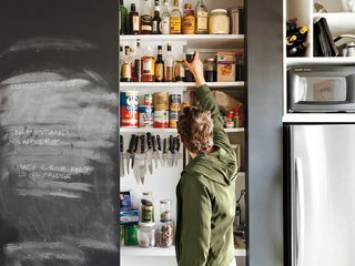 Closet Case<br><br>To consolidate most appliances and food storage, keep his compact kitchen looking neat, and save money on cabinets, Sherman built a closet into the kitchen wall ("Cabinets are expensive but closets are cheap," he offers). Inside is a countertop, blackboard surface, toaster oven, garbage cans, magnetic knife rack, and plenty of shelves. When the doors are closed, the unit recedes from view.