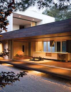 An Atypical Modern Home in Southern California - Photo 8 of 15 - Protected by an overhang, and floating above ground level, this tertiary space is known in traditional homes as the "engawa." To sustain a unified look throughout, the floor and ceiling are clad in ipe wood.