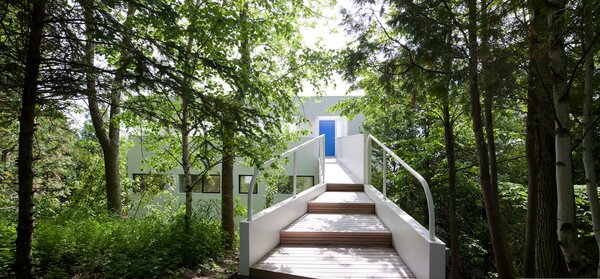 The view from the driveway highlights the bright-blue entrance doorway.