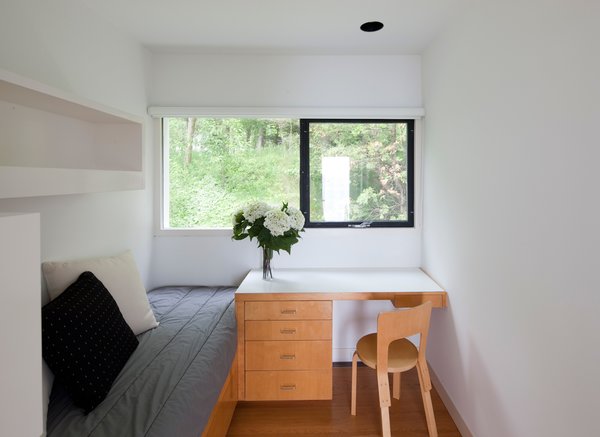 A desk in the guest bedroom fits tidily next to the bed.