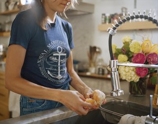 Helen Nissenboim washes produce at the sink, which, along with the faucet, is made by Vigo and sourced from Overstock.com.