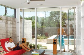 In the corners of the kitchen and living room, narrow screened doors let the southeast breezes flow through the home and allow the remaining glass windows to stay fixed and clear.