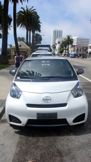 The iQ seems incredibly manageable when parked in front of a minivan, a Sprinter van and a tour bus.