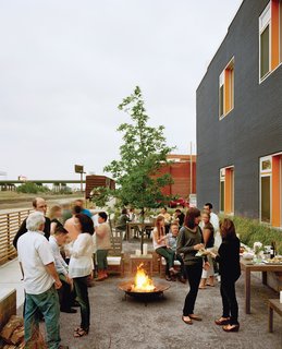 Architect Douglas Stockman says the building's charcoal-and-orange exterior coloring was "intended to reflect the dynamic character of the neighborhood." Here, it provides a festive backdrop to the residents' semi-annual Finn Lofts community party.