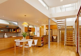 The living room, dining room and kitchen are in one open space. The flooring is bamboo. The cabinetry is a mix of bamboo, walnut, and maple, and was fabricated by City Cabinetmakers out of San Francisco.