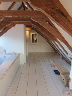 25 Homes With Exposed Beams: Rustic to Modern - Photo 25 of 25 - A very steep and narrow flight of stairs leads to one of the best parts of the room at the Dylan in Amsterdam: a big bathroom tucked into the attic that has original wooden beams arching overhead.