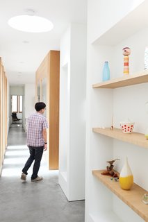The couple's collection of books, pottery, and carvings are displayed on built-in shelves in the office and hallways.