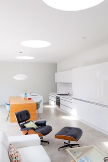 Though loads of natural light comes in from the courtyard, these large skylights also afford a view of the sky. The coffee table is from Modernica and the Eames Lounge is from Herman Miller.