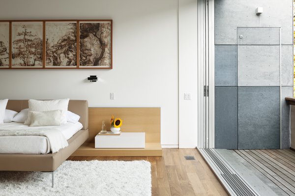 In the bedroom, walls painted with benjaminmoore.com Aura matte paint complement the insulated concrete panels that clad the exterior walls. The floors are walnut, and sealed with Osmo Polyx-Oil, a finish made with sunflower, soybean, and thistle oil.